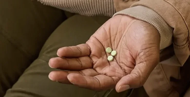 a man holding Found weight loss tablets in his hand